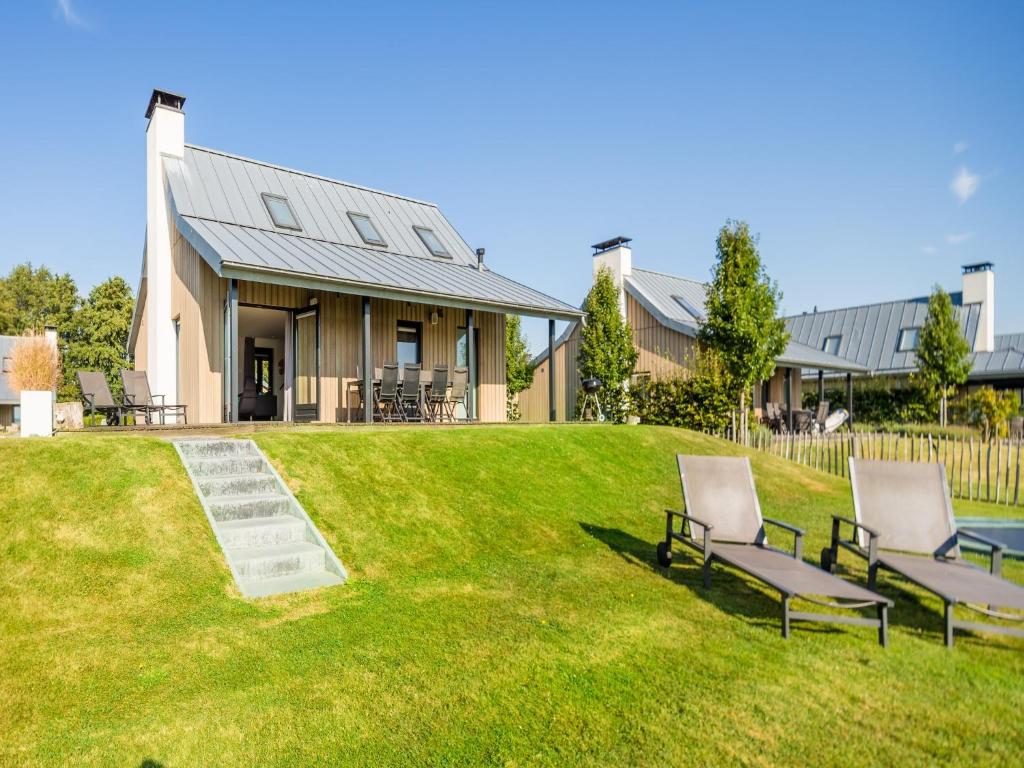 a house with two chairs on a lawn at Villa Oesterdam Sleeps 8 persons in Tholen