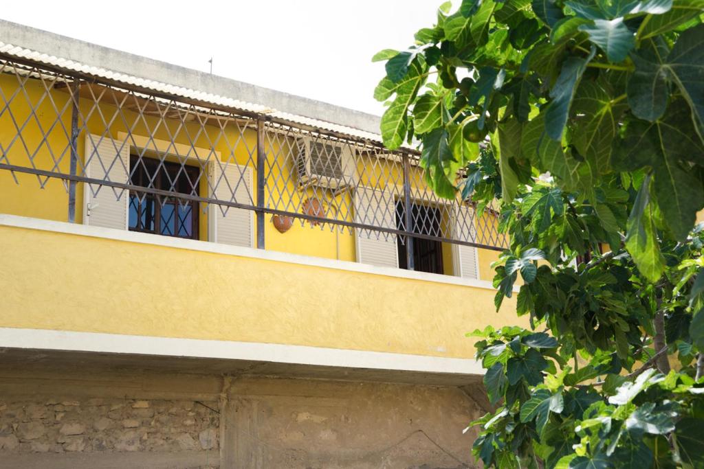 een geel en wit gebouw met een balkon bij Casa Vacanza da Luisa in San Giovanni Suèrgiu