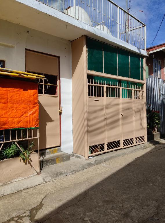 ein Gebäude mit einer offenen Tür und einem Zaun in der Unterkunft TS Transient House in Baguio City