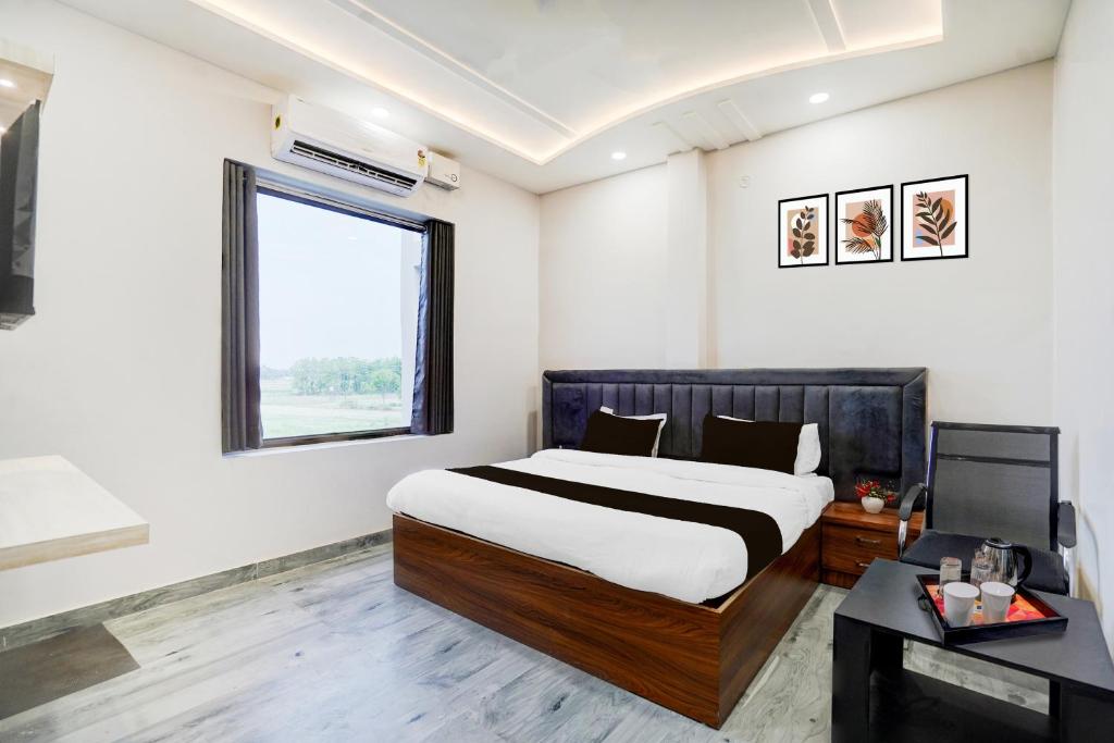 a bedroom with a large bed and a window at Super Hotel O Hanuman Gadi Formerly Alankar Lawn in Varanasi