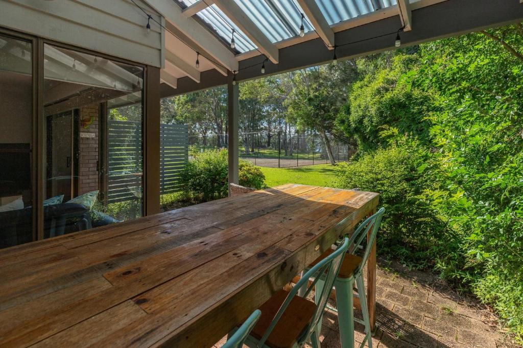 a wooden table on the back porch of a house at Sandpiper 16 in Smiths Lake