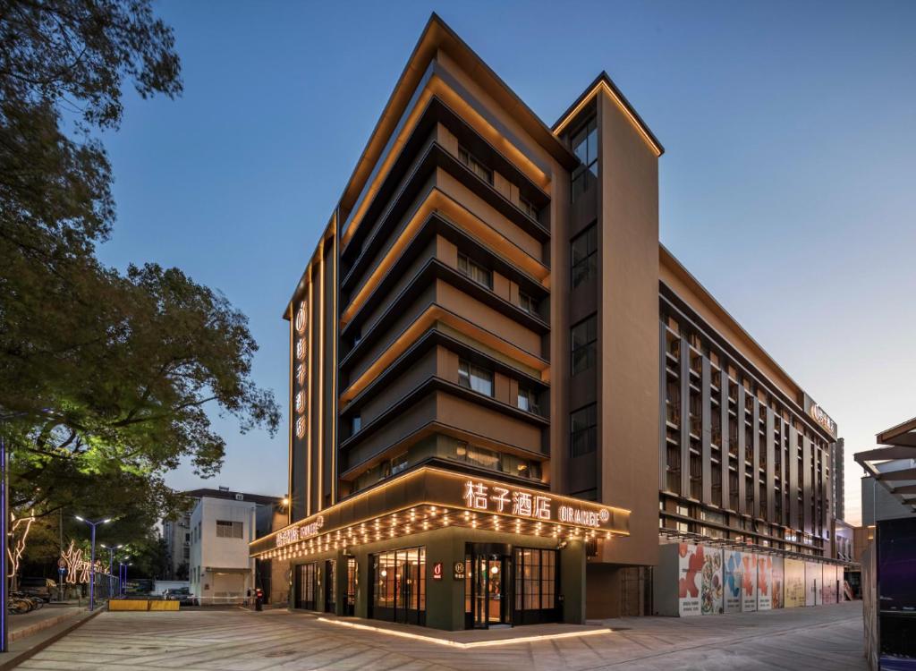 un palazzo alto con un cartello sulla parte anteriore di Orange Hotel Shanghai Meilong Wanhui International Plaza a Shanghai