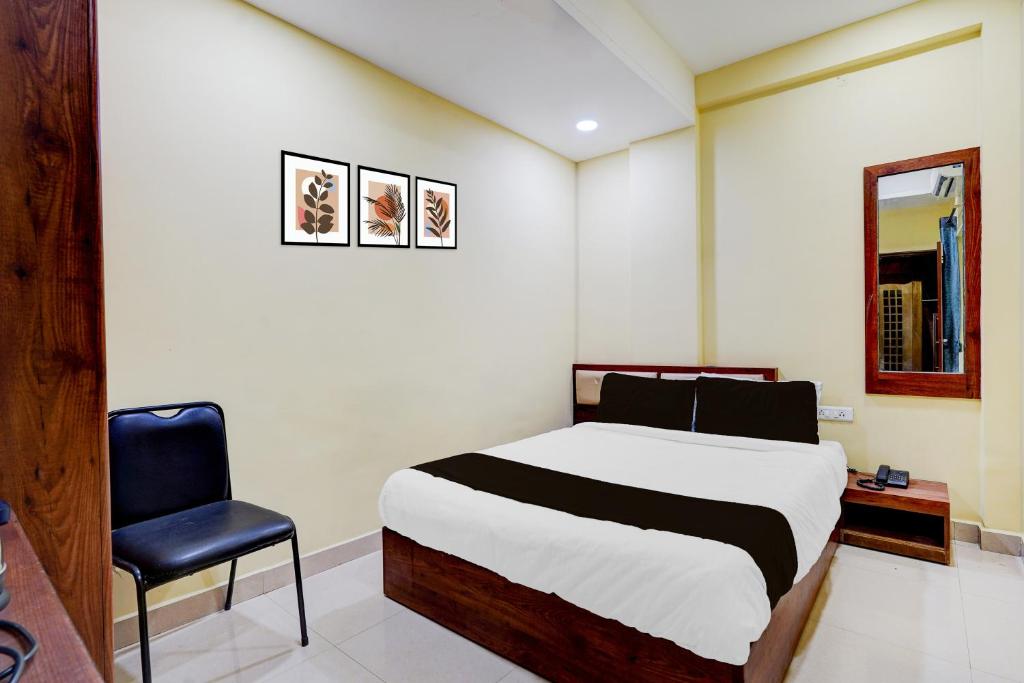 a bedroom with a bed and a blue chair at Super Collection O Vadapalani Metro Station Formerly Pineapple Guest House in Chennai