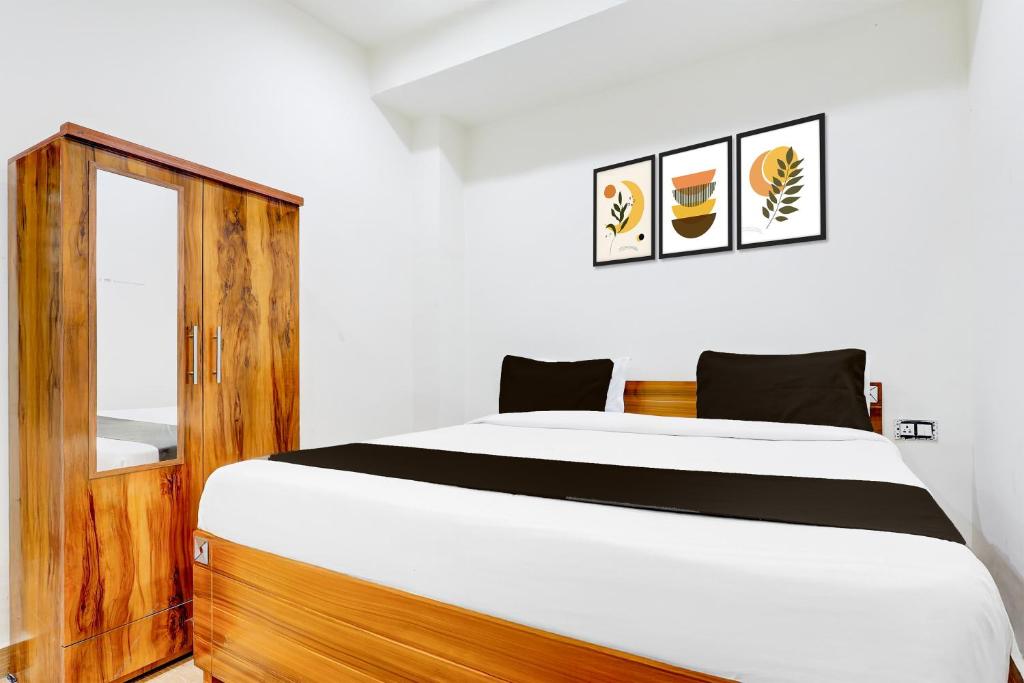 una camera da letto con un letto e un armadio in legno di Collection O Sector 62 Faridabad a Ballabgarh