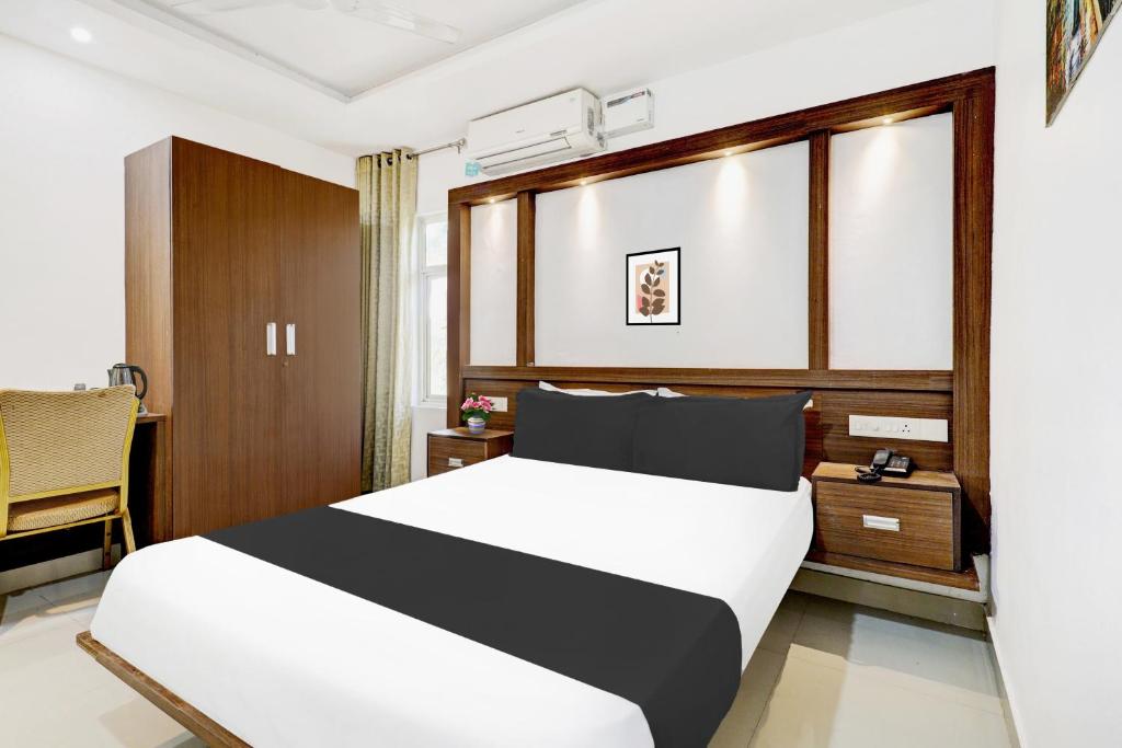 a hotel room with a bed and a desk at Hotel O Kazhakoottam Near AL SAJ Convention Centre in Trivandrum