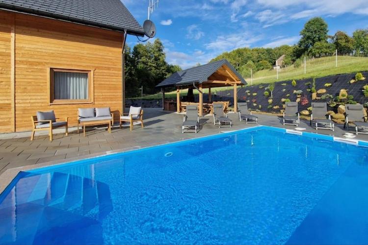 una gran piscina azul junto a una casa en Holiday Home in Wi niowa with Pool and Forest, en Iwierzyce