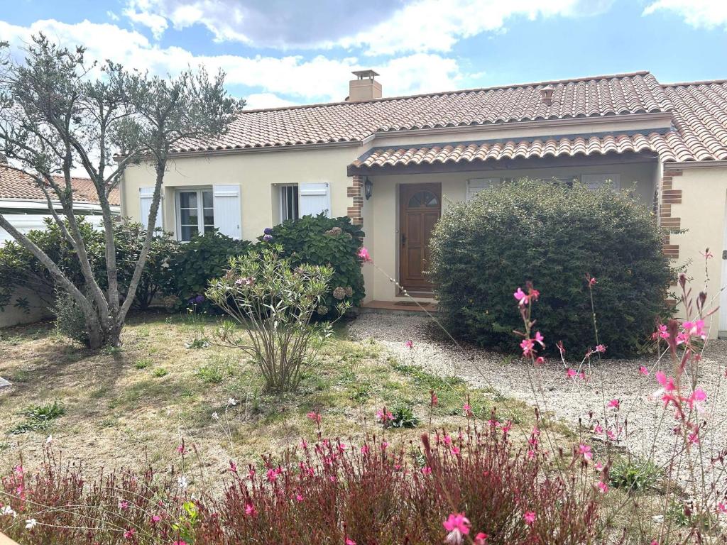 a house with a garden with flowers in front of it at Mais 5 pièces 8 couchages SAINT HILAIRE DE RIEZ - FR-1-224-822 in Saint-Hilaire-de-Riez