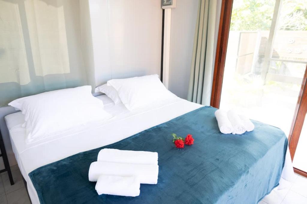 Un dormitorio con una cama con toallas y fresas encima. en Fare Miri Miri, en Haapiti