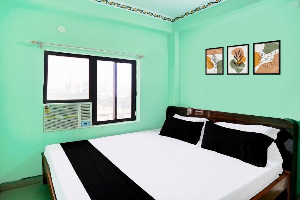a bedroom with a bed with blue walls and a window at Super Hotel O Bhagwanpur Chowk Muzaffarpur in Muzaffarpur