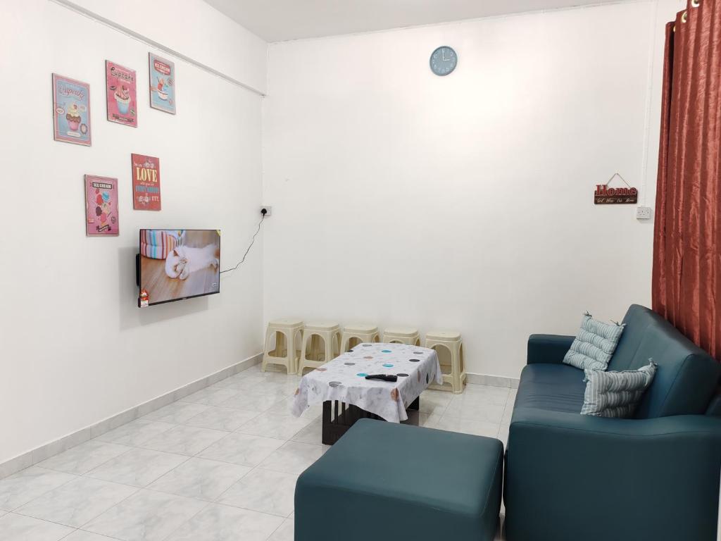 a living room with a blue couch and a table at Tracy Homestay Tmn Indah Jaya in Sandakan