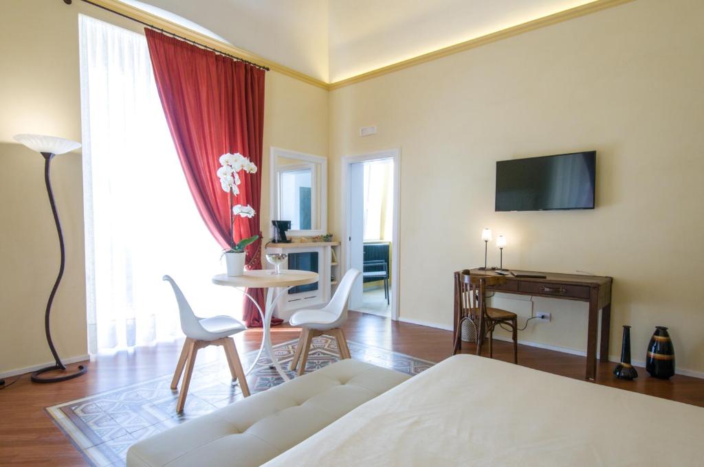 1 dormitorio con 1 cama, mesa y sillas en Turenum Apartment B&B, en Trani