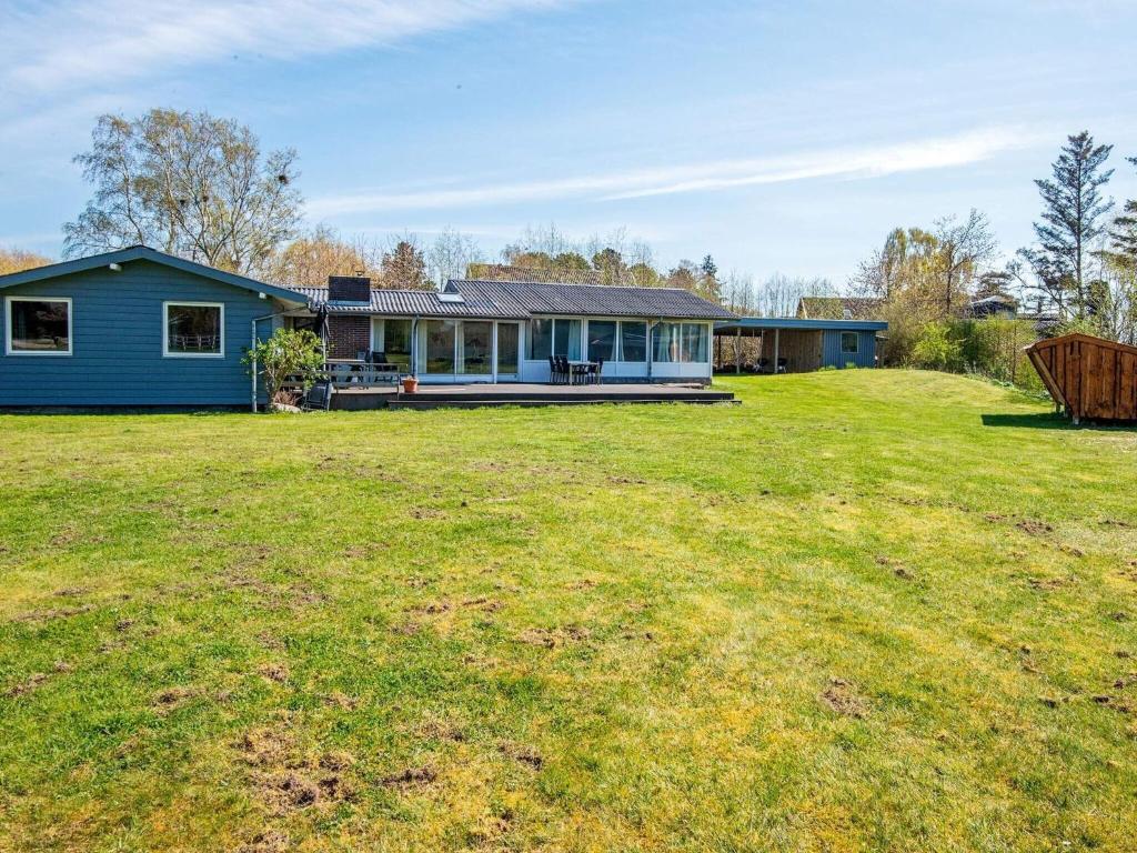 niebieski dom z dużym dziedzińcem przed nim w obiekcie 8 person holiday home in Knebel w mieście Knebel