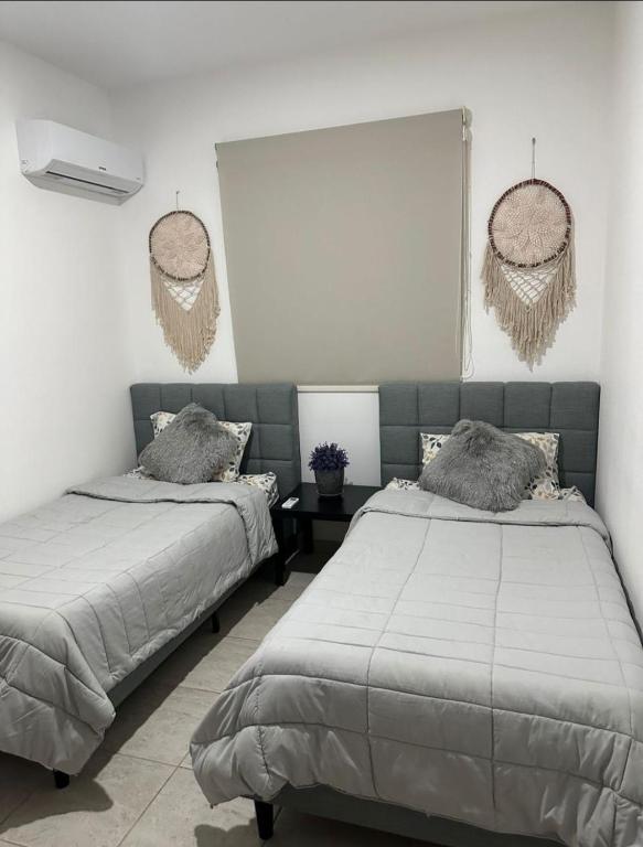 a bedroom with two beds and a window with baskets at Haven de descanso y relajación in Puerto Morelos