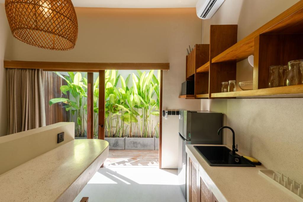 a kitchen with a sink and a refrigerator at Casa Komang, lovely studio in central Bingin in Uluwatu