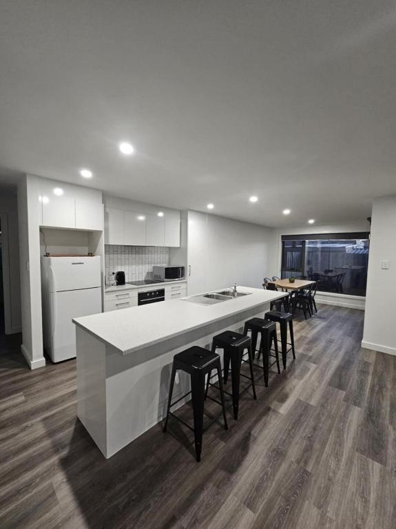 a kitchen with a large white counter and stools at George Town Villa - Outdoor Alfresco - aircon FREE WIFI - Central location near MTB Trails in George Town