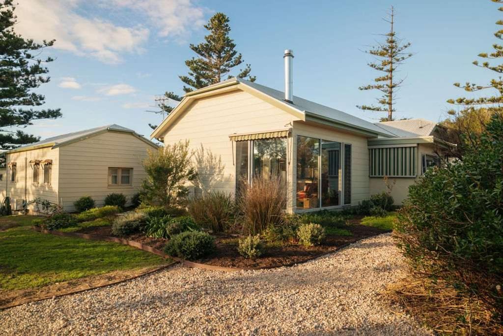 a white house with a garden in front of it at Chiton Cottage by the Sea - Restaurants, Bikes, Pets in Hayborough