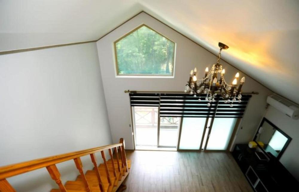 InjeにあるInje Good Morning Pensionのシャンデリアと窓のある階段付きの客室です。