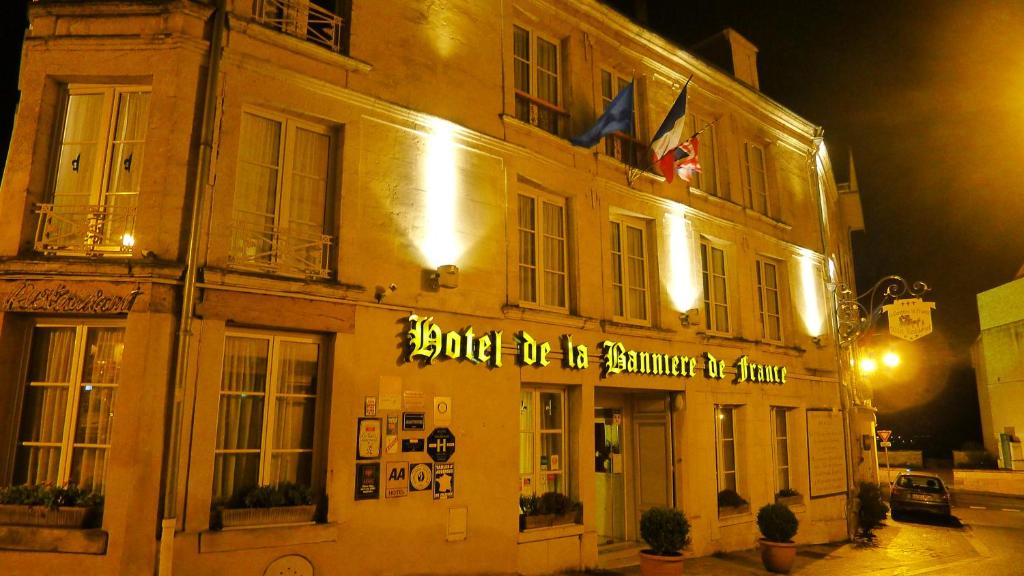 a building with a sign on the side of it at Hôtel De La Banniere De France in Laon