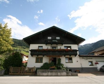 un grand bâtiment blanc avec un toit noir dans l'établissement Haus Elisabeth, à Mittersill