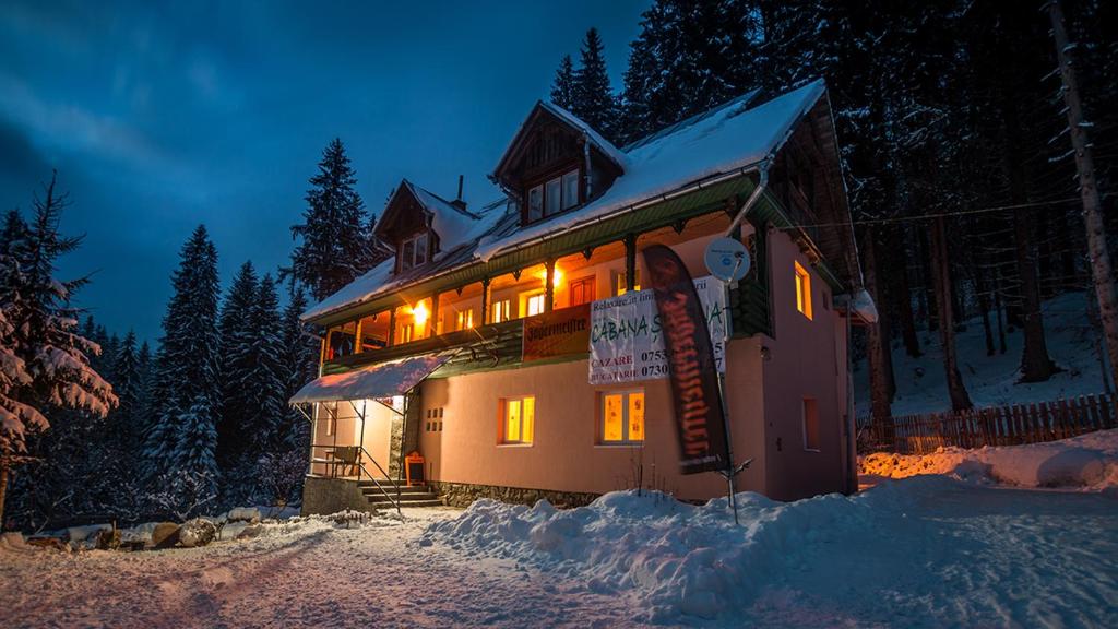 Una casa en la nieve por la noche en Cabana Sestina, en Salard