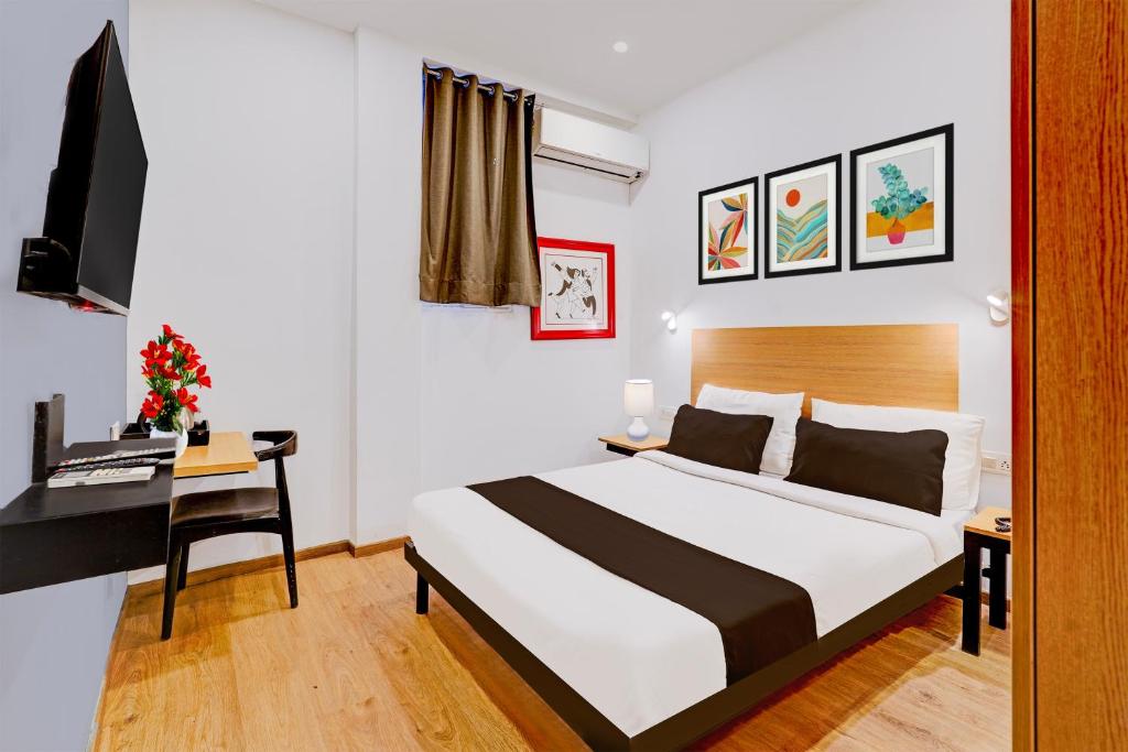 a bedroom with a bed and a desk with a computer at Super Townhouse Pondicherry in Puducherry