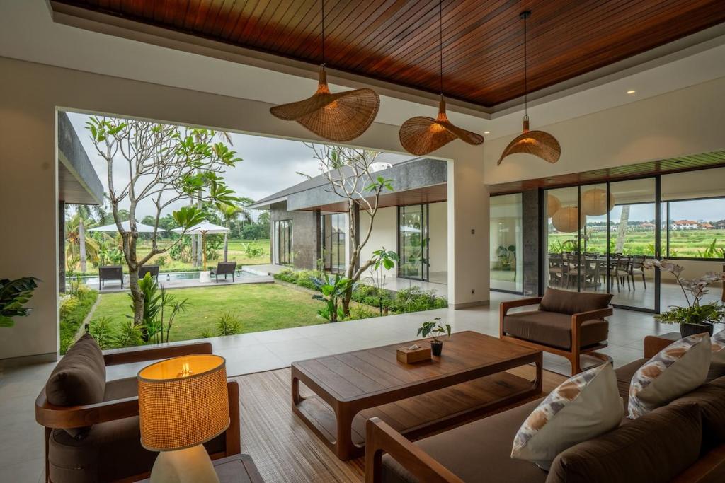 a living room with a couch and a table at 4BR Rice Fields view & Spa Villa Abian in Sukawati