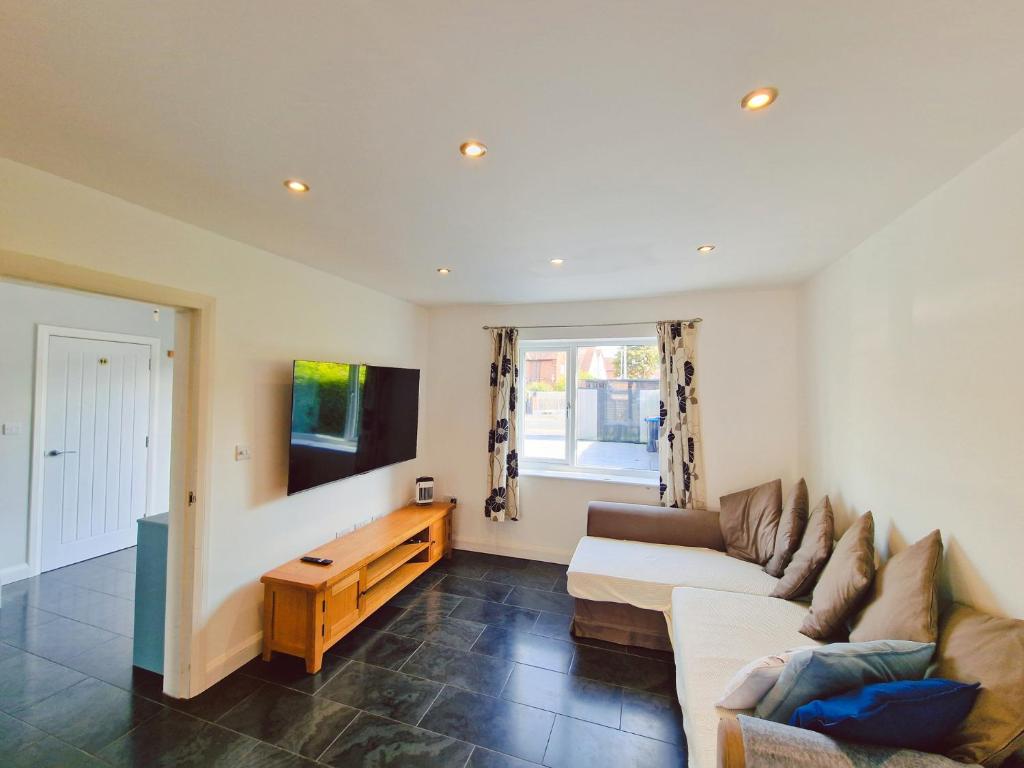 a living room with a couch and a tv at 5 star Luxury Home in a Magnificent area -Chester in Hough Green