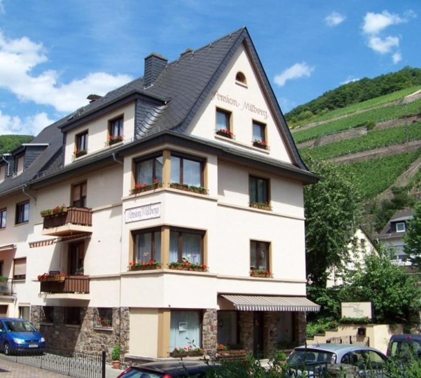 un gran edificio blanco con techo negro en Pension Milberg Assmannshausen en Rüdesheim am Rhein