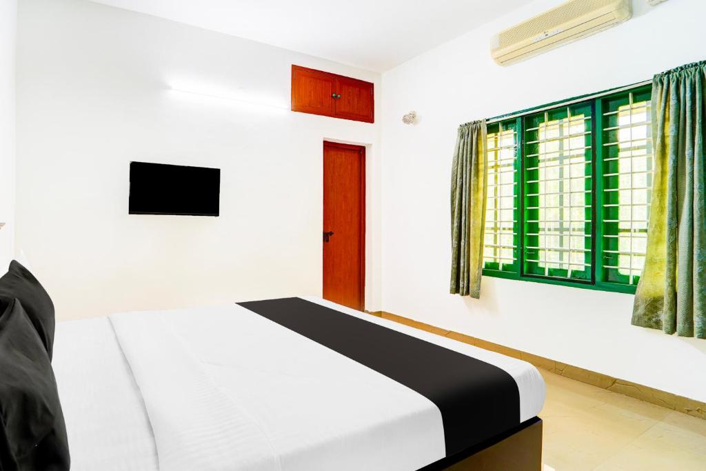 a bedroom with a bed and a window at Super Hotel O Vennala Near Palarivattom in Ernakulam