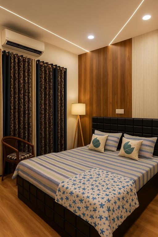a bedroom with a large bed with blue and white sheets at Vinayaka Heritage in Patna