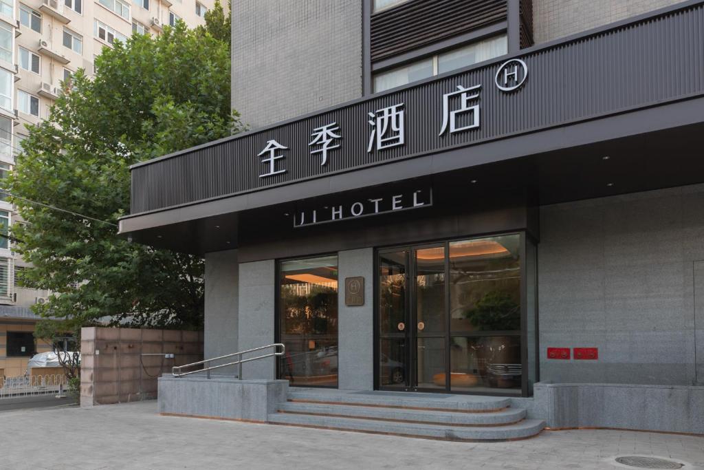 un negozio di fronte a un edificio con scritte sopra di JI Hotel Beijing Olympic National Convention Center a Pechino