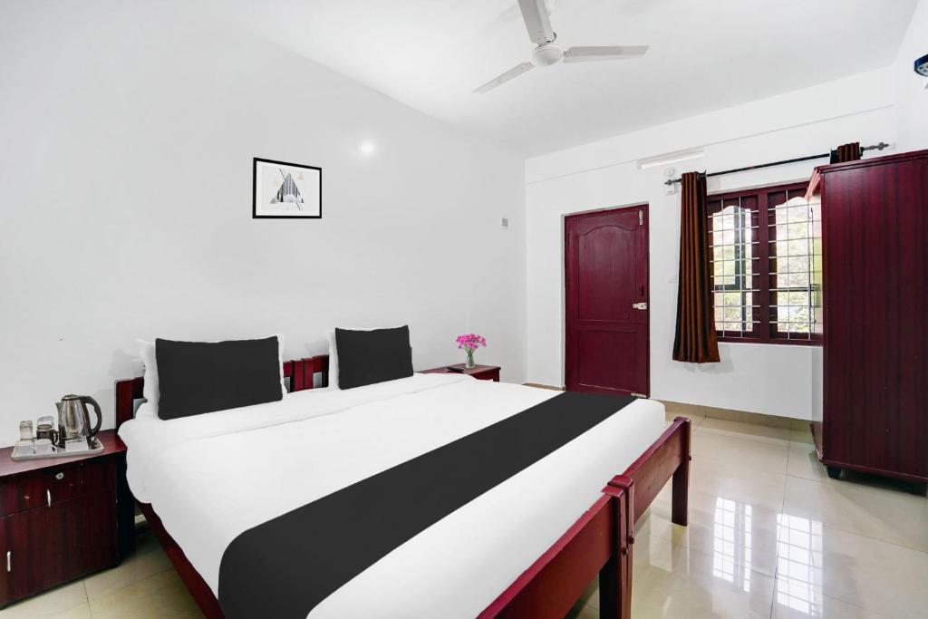 a bedroom with a large bed in a room at Super Hotel O Sultan Bathery formerly Bluevalley in Wayanad