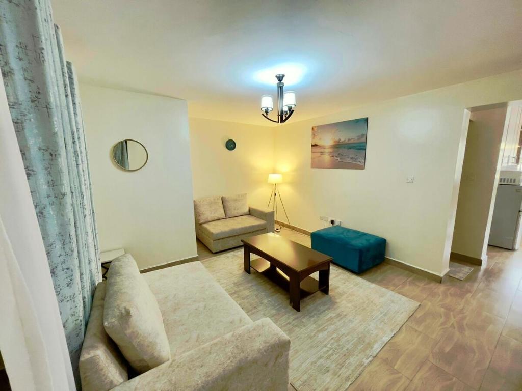 een woonkamer met een bank en een tafel bij Sweethaven in Nairobi