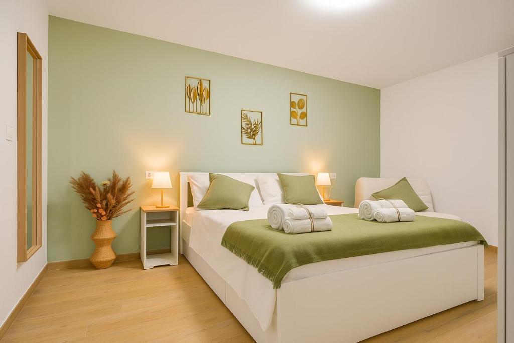 a bedroom with a white bed with green and white pillows at Alice al Mare in Pescara