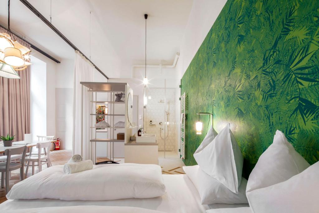 a bedroom with a bed and a green wall at grätzlhotel Karmelitermarkt in Vienna