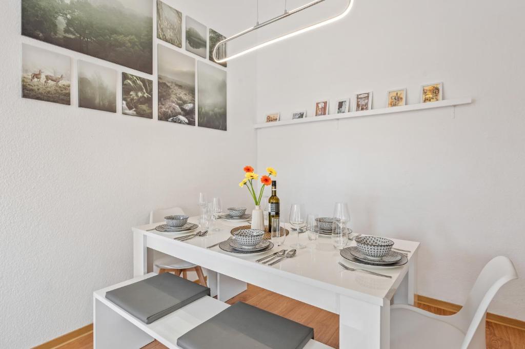 a white dining room with a white table and chairs at Fewo Waldegg, gemütliche Unterkunft für 5 Gäste in Bad Friedrichshall