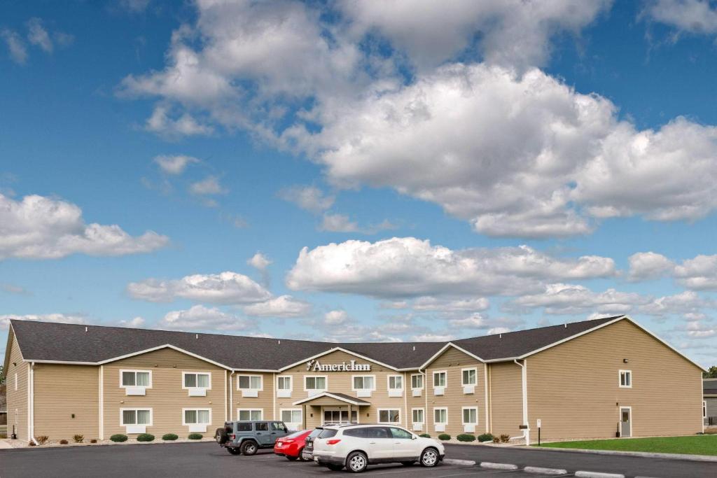 a large building with cars parked in a parking lot at AmericInn by Wyndham Sleepy Eye in Sleepy Eye