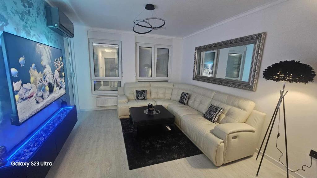 a living room with a white couch and a tv at Luxury Apartments Black Diamond in Ši Selo