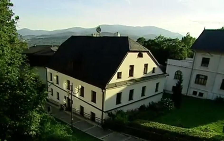ein großes weißes Haus mit schwarzem Dach in der Unterkunft Apartmá v Rodném domě Vincenze Priessnitze v centru lázní in Jeseník