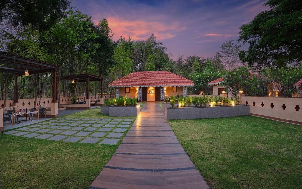 a walkway leading to a house with a pavilion at MeruVann, Kanha National Park in Bhimlath