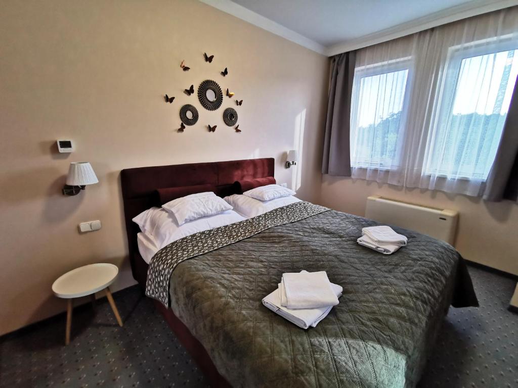 a hotel room with a bed with towels on it at Aquakaros Apartman Zalakaros in Zalakaros
