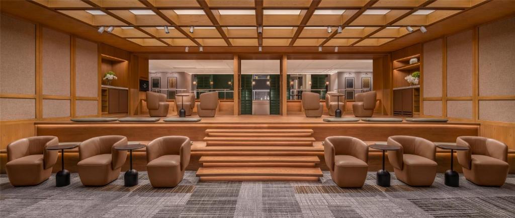 A quiet lounge with armchairs arranged around a broad central staircase.