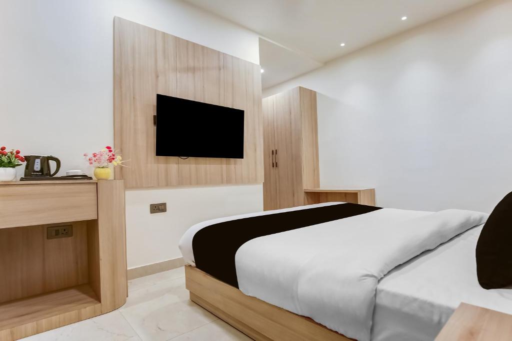 a bedroom with a bed and a tv on a wall at Hotel O S.C HEIGHTS in Amritsar
