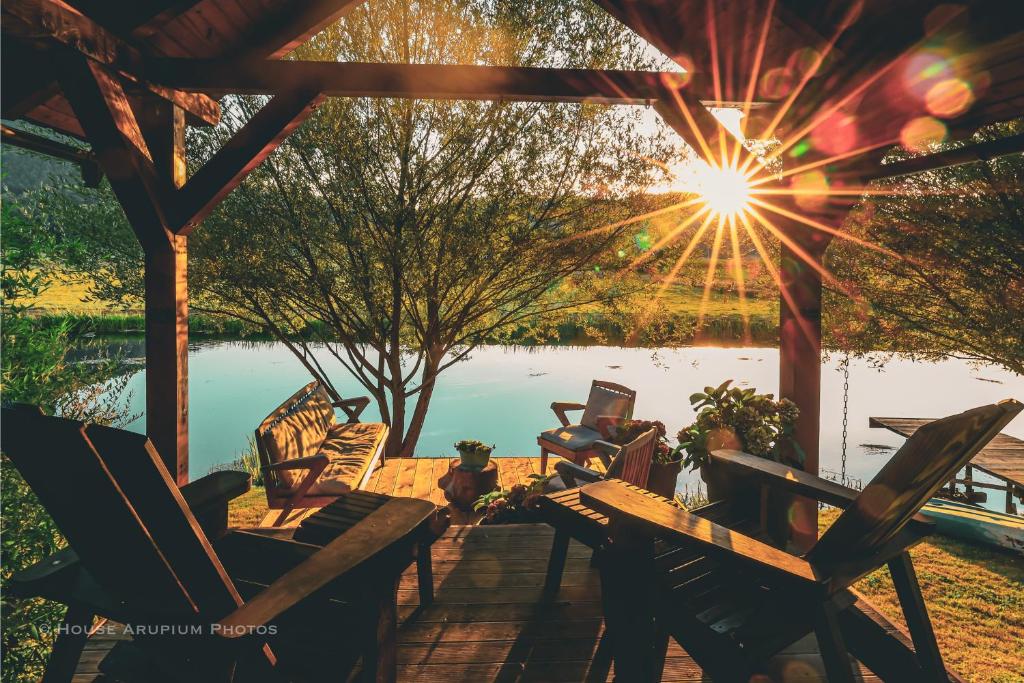 a group of chairs sitting on a deck near a lake at House Arupium - HOT TUB in Otočac