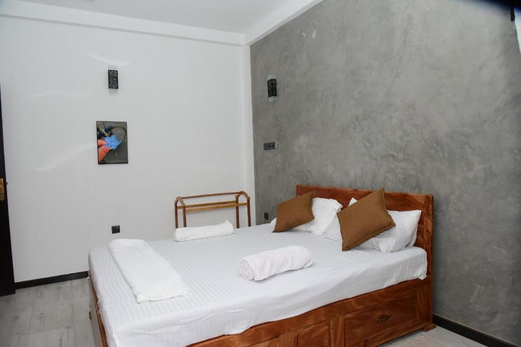 a bedroom with a bed with white sheets and pillows at Tranquile Viwe in Gonapinuwala West
