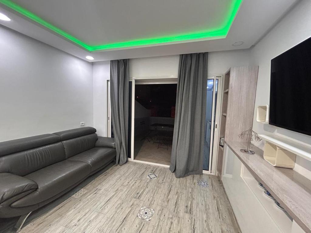 Una sala de estar con un sofá y un televisor de pantalla plana. en Bel Azur de Sidi Bou Said, en Sidi Bou Saïd