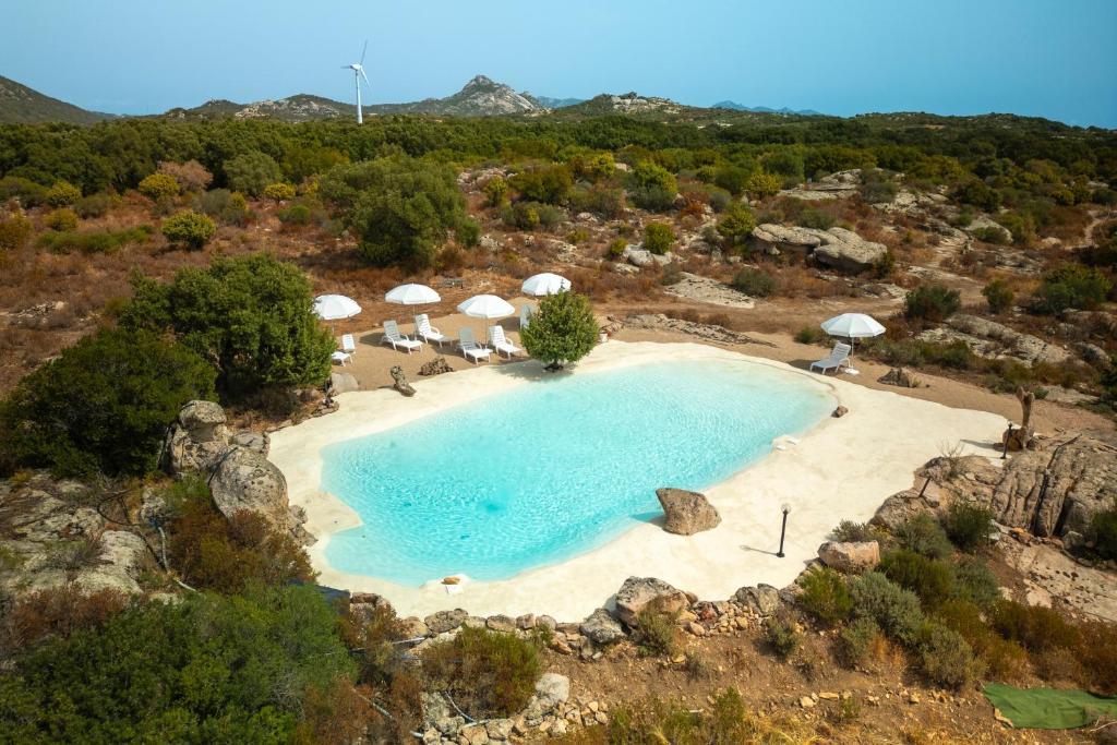 an aerial view of a large pool with umbrellas at Villa Alcumissu in Calangianus