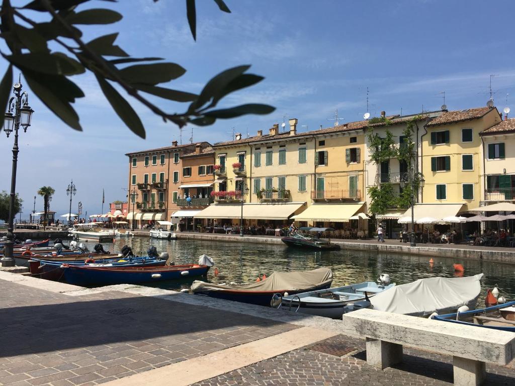 un grupo de barcos atracados en un canal con edificios en Oreste Suite, en Lazise