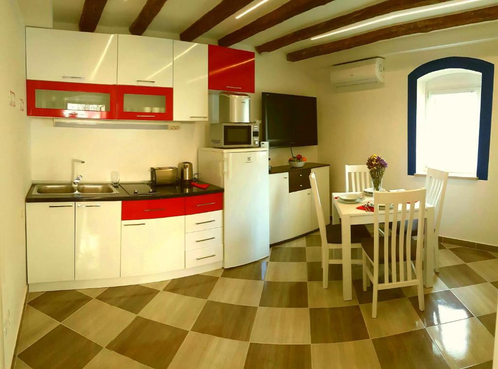 eine Küche mit weißen Geräten und einem Tisch mit Stühlen in der Unterkunft Karmen's Apartment One in Split