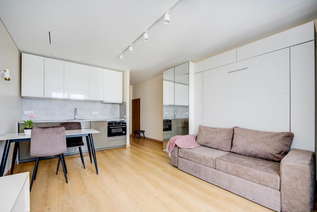 un salon avec un canapé et une table dans l'établissement Pradoli apartament, à Vilnius